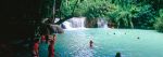 Panoramic shot of travellers swimming in pool at Kwang Si waterfall